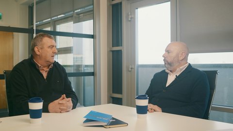 Two men having a chat over coffee.